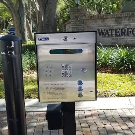Community gate intercom at a residential entrance with directory keypad